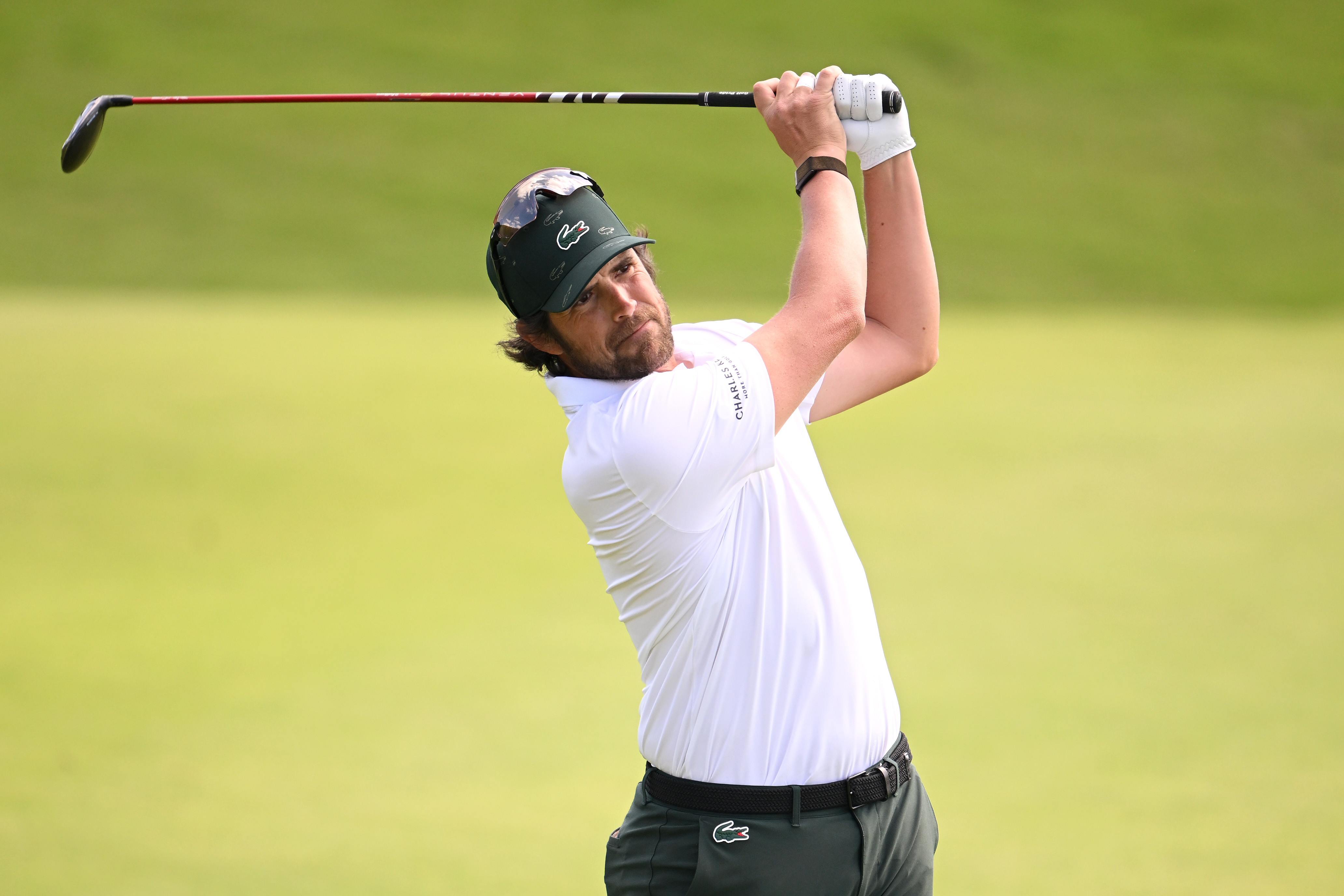 Nacho Elvira hits a golf shot and watches it in the air