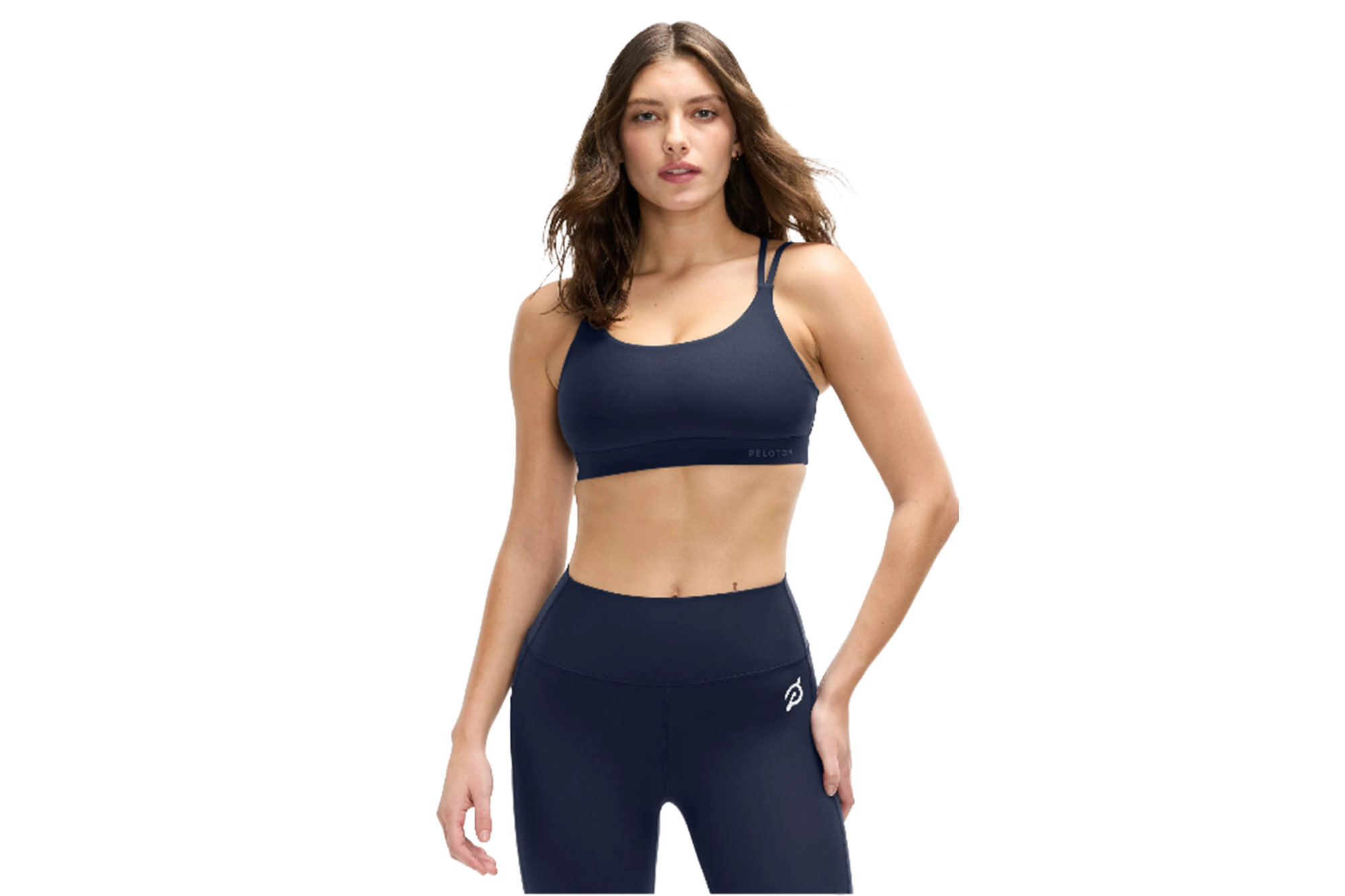 Woman wearing navy Peloton sports bra and leggings.