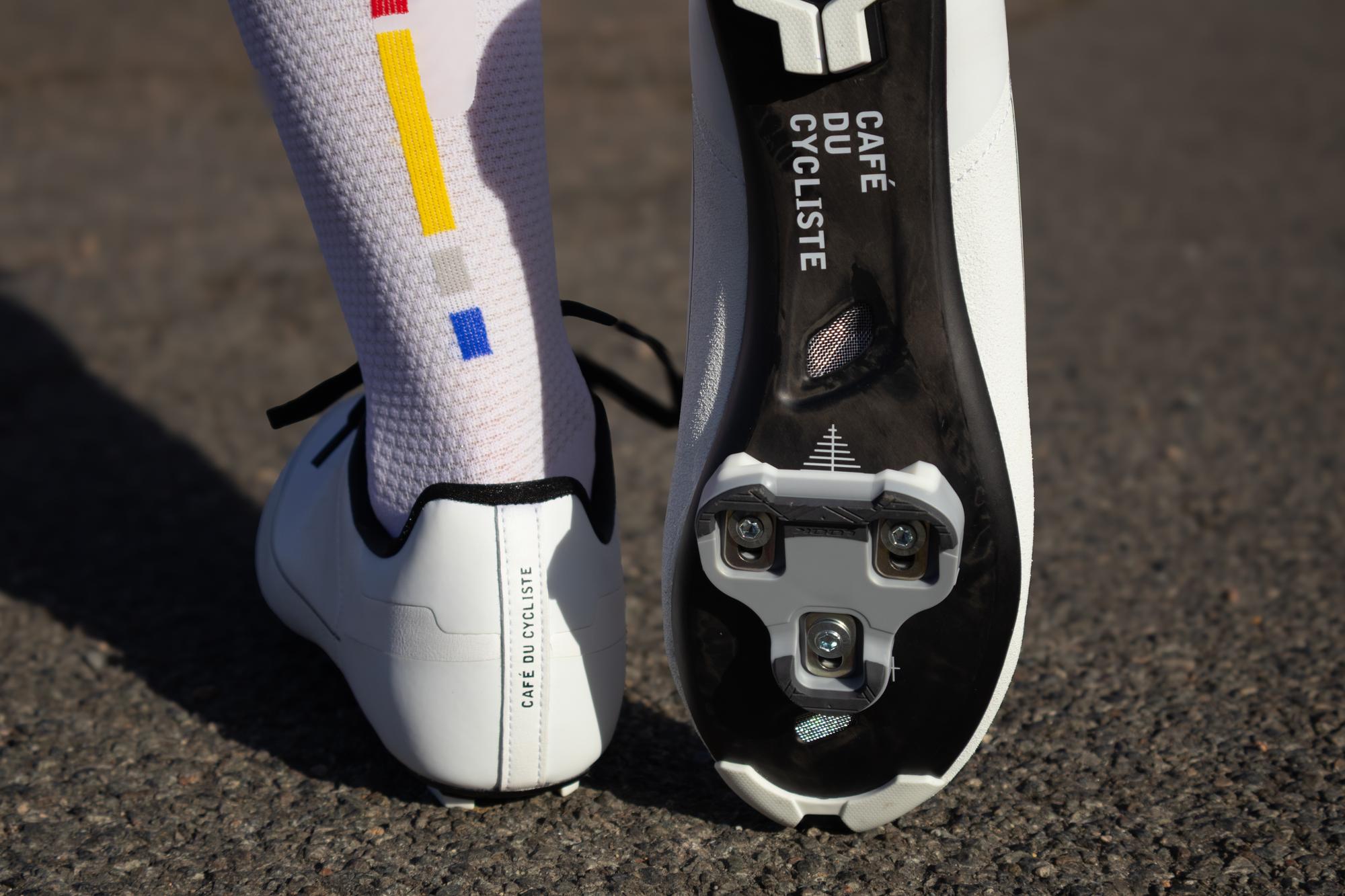 a cyclists feet and shoes showing the sole and cleat on a carbon sole