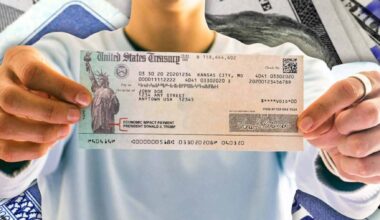 Person holding a U.S. Treasury Social Security check as new reports warn of a possible 23% automatic benefit cut