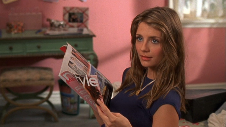 Mischa Barton as Marissa sitting in a pink bedroom holding magazine in The O.C.