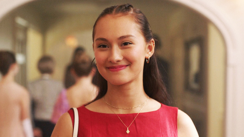 Belly Conklin smiles while walking down a hallway in The Summer I Turned Pretty