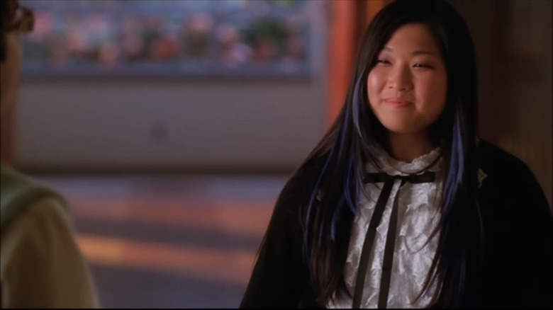 Jenna Ushkowitz as Tina with purple streaks in hair smiling at Kevin McHale as Artie (mostly out of frame) in Glee