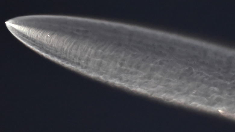 A SpaceX Falcon 9 heading into orbit, leaving a long trail behind it