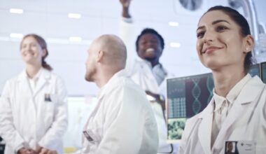 Researchers smile in a lab setting.