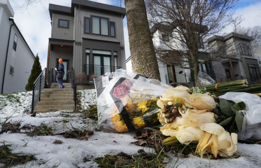 Flowers adorn the curb outside the home where Monique and Spencer Tepe were found dead.