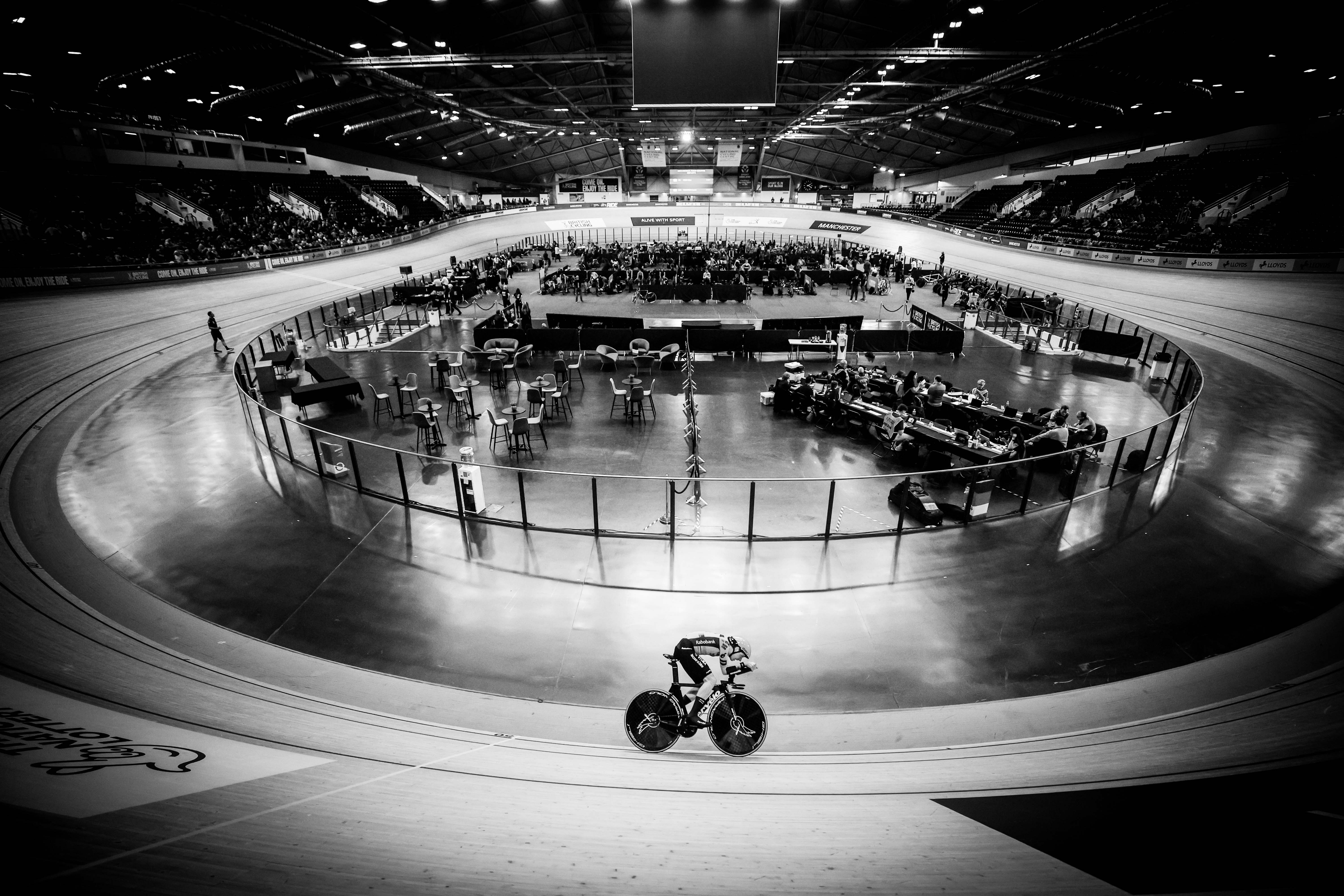 Black and white photo of a cyclist on a velodrome track during the Lloyds National Track Championships.