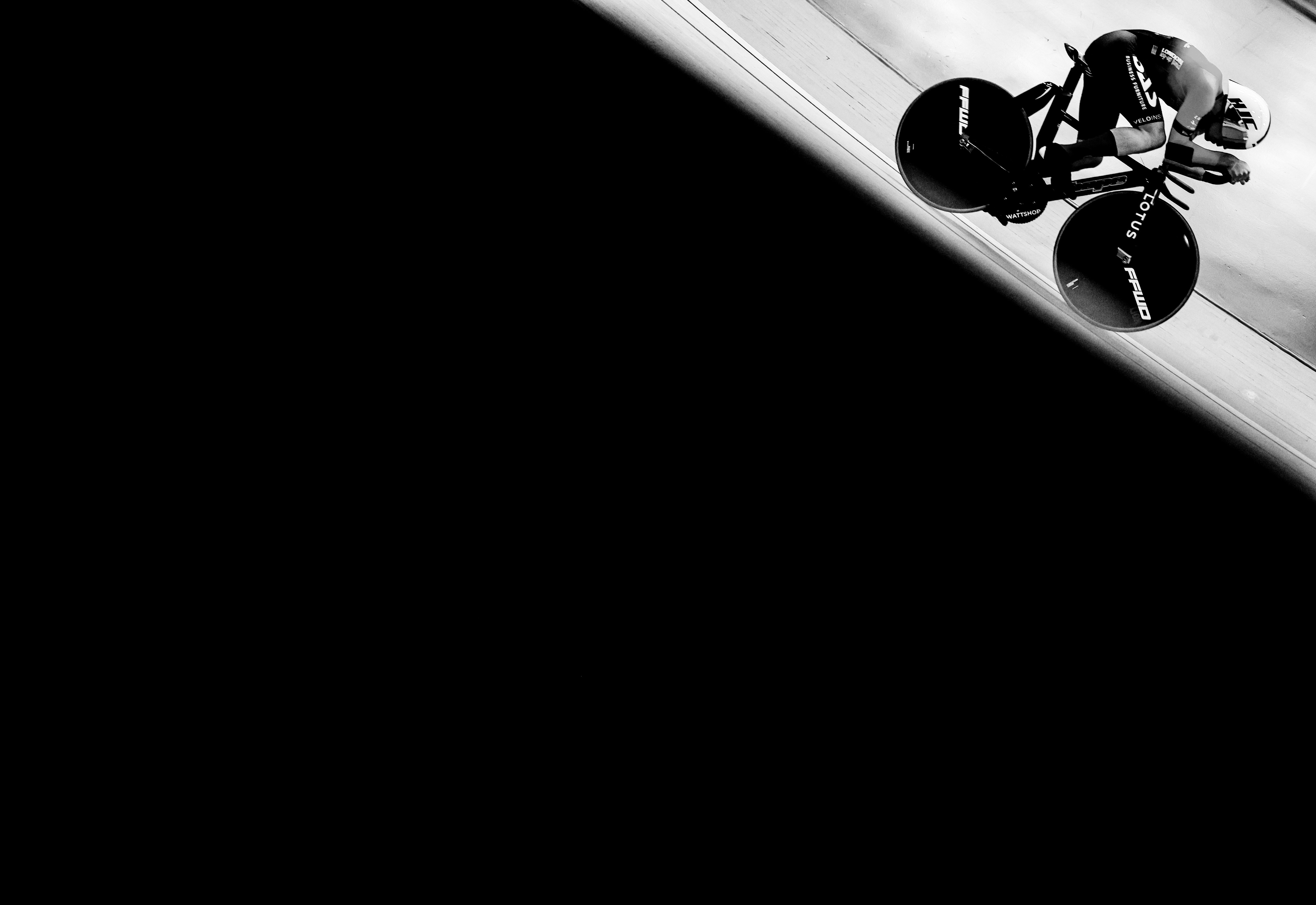 A cyclist on a track in a black and white shot.