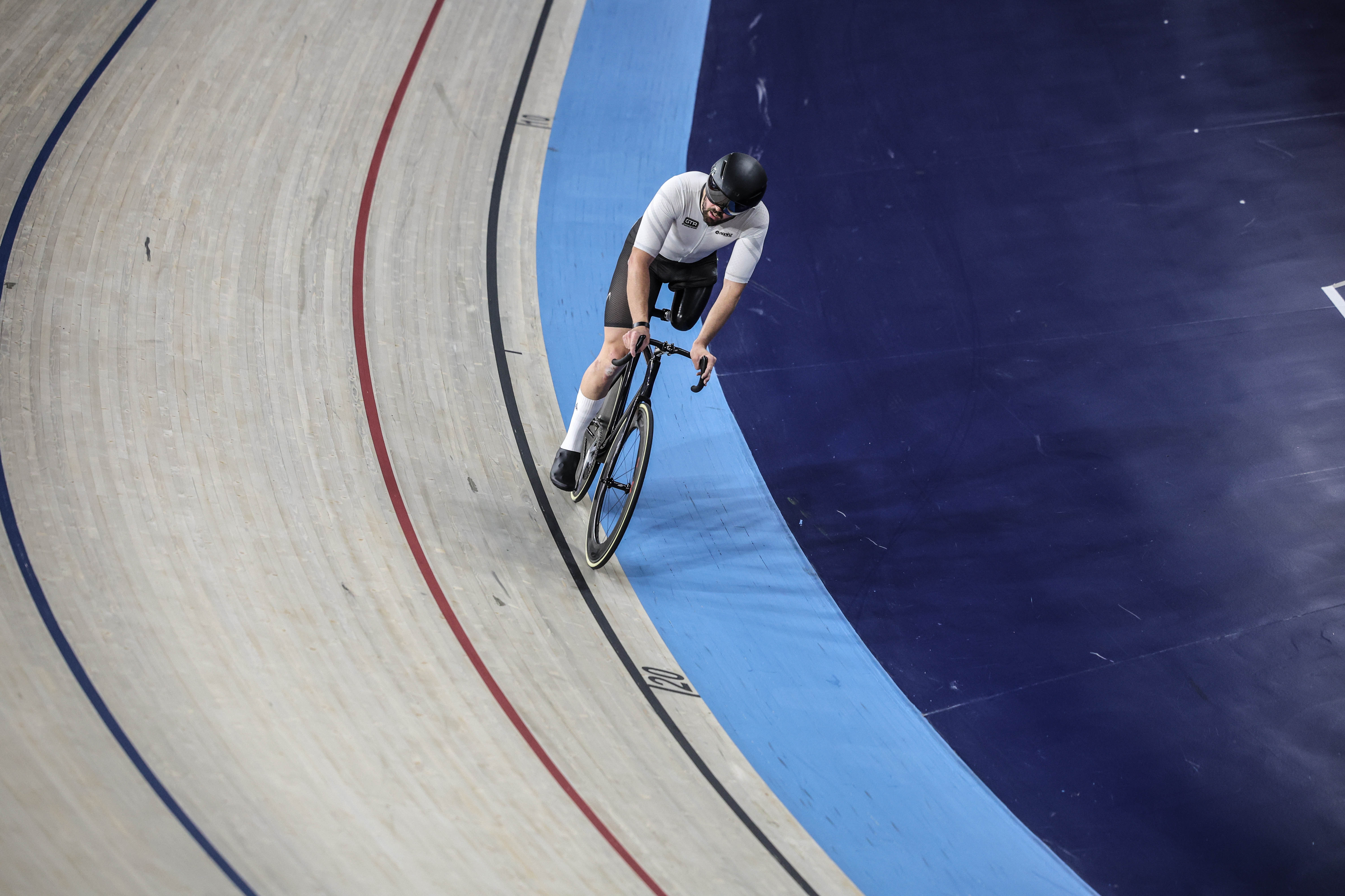 A cyclist on a track with a prosthetic leg at the Lloyds National Track Championships.