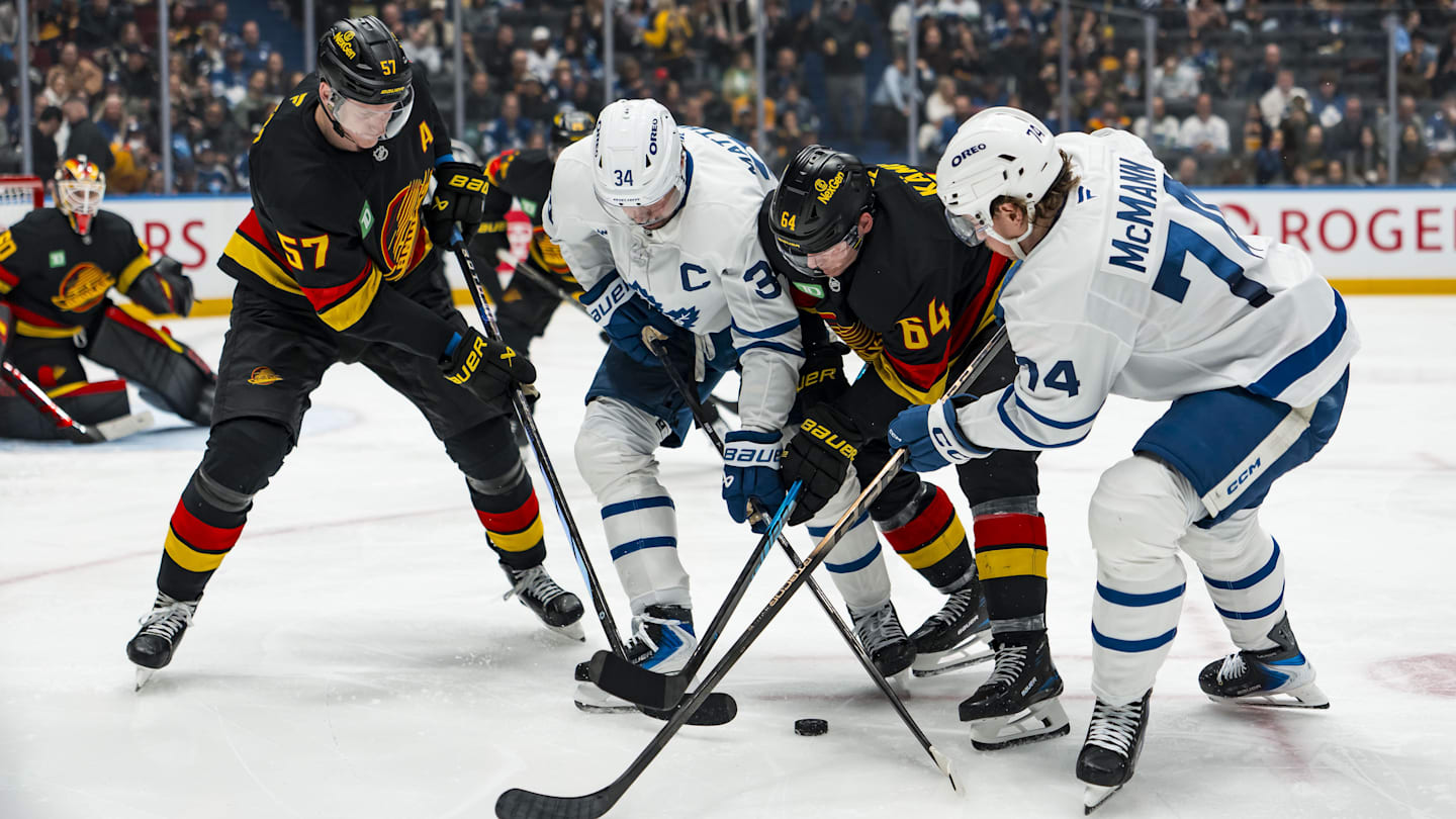 Jan 31, 2026; Vancouver, British Columbia, CAN; Vancouver Canucks defenseman Tyler Myers (57) and forward David Kampf (64) battle with Toronto Maple Leafs forward Auston Matthews (34) and forward Bobby McMann (74) in the third period at Rogers Arena. Mandatory Credit: Bob Frid-Imagn Images