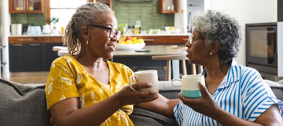 Two older African American women chatting over coffee.