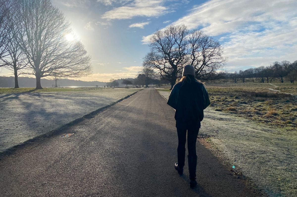 Woman walking on a path in a park on a frosty day