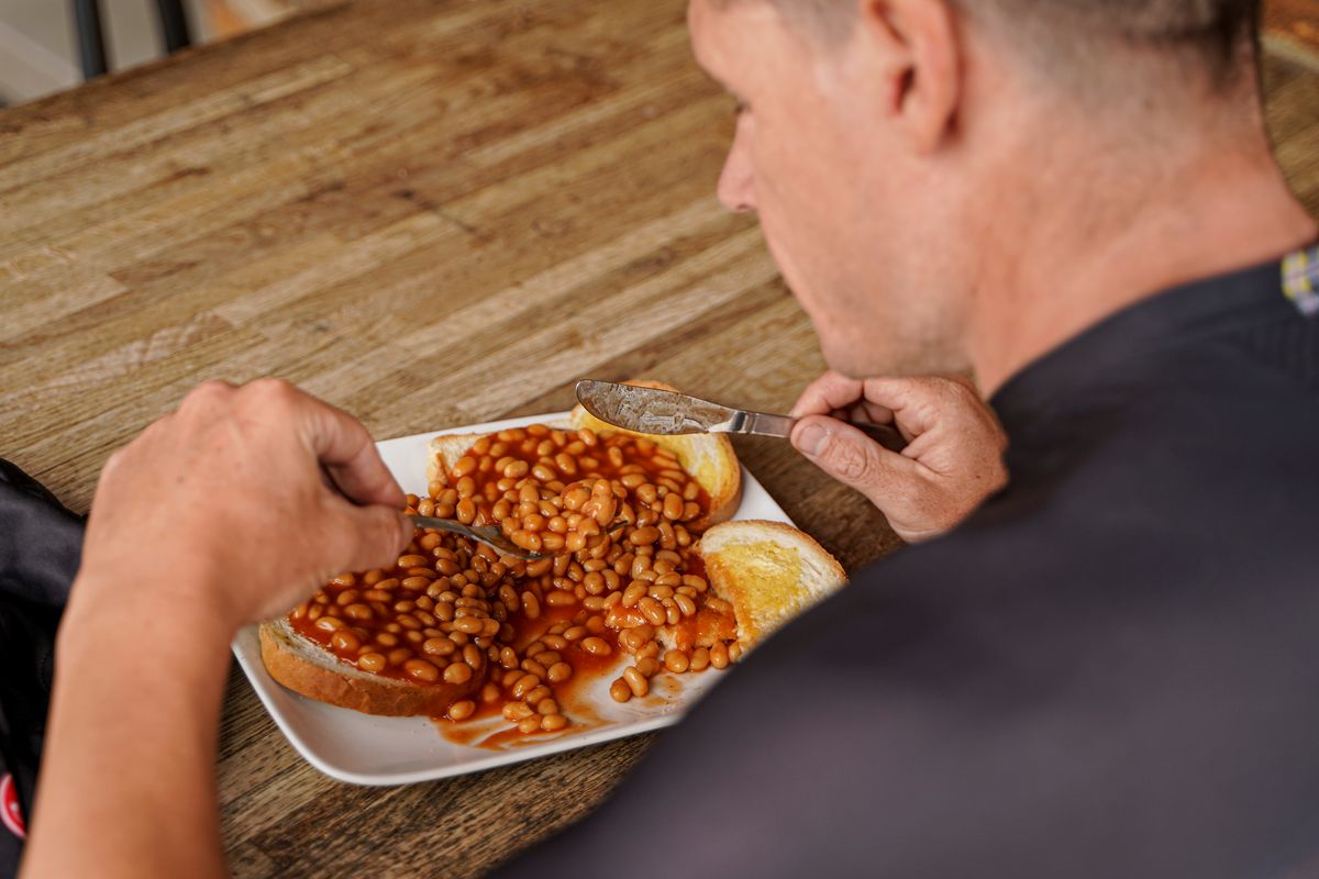 Man eating beans on toast
