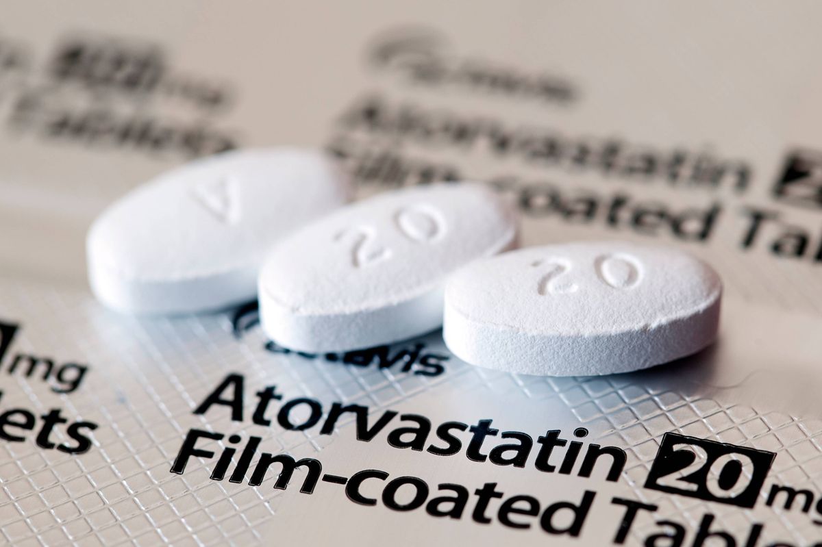 Aberdeen, Scotland - April 7, 2014: Close up view of three Atorvastatin tablets. Atorvastatin is a member of the drug class known as statins, used for lowering blood cholesterol levels.
