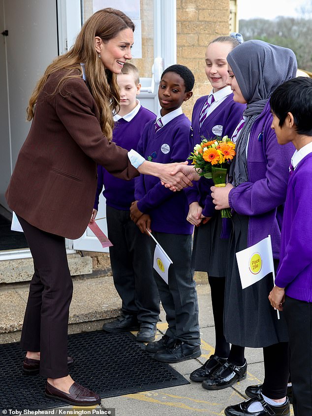 Kate, 44, beamed while chatting to students at Castle Hill Academy - for her work as patron of mental health charity Place2Be