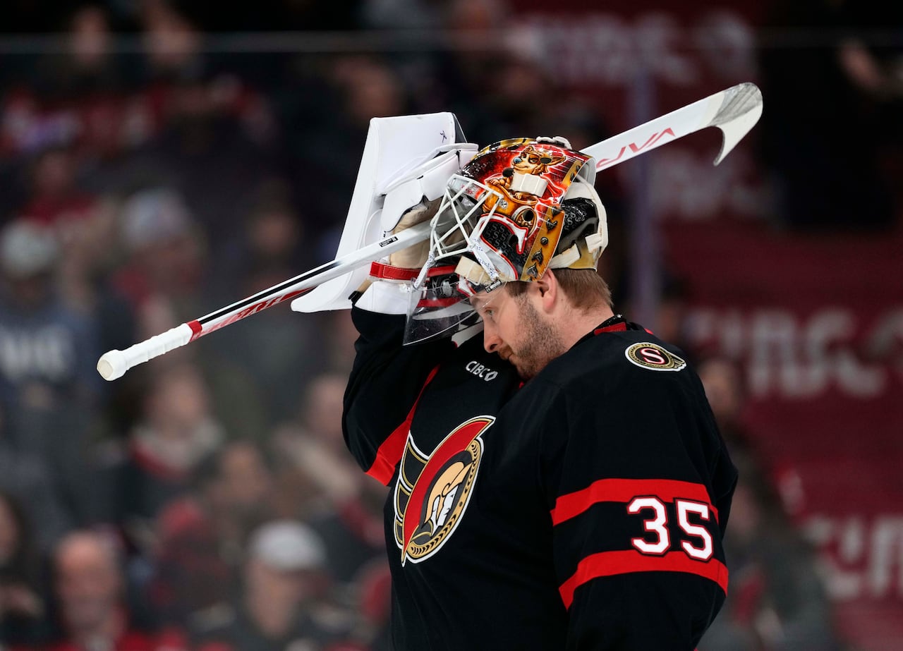 Ottawa Senators goaltender Linus Ullmark with his helmet half on his head.