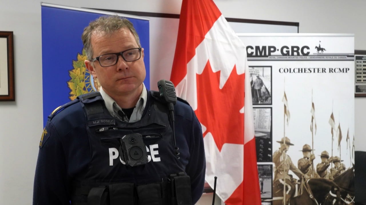 A man wearing a police uniform inside a briefing room.