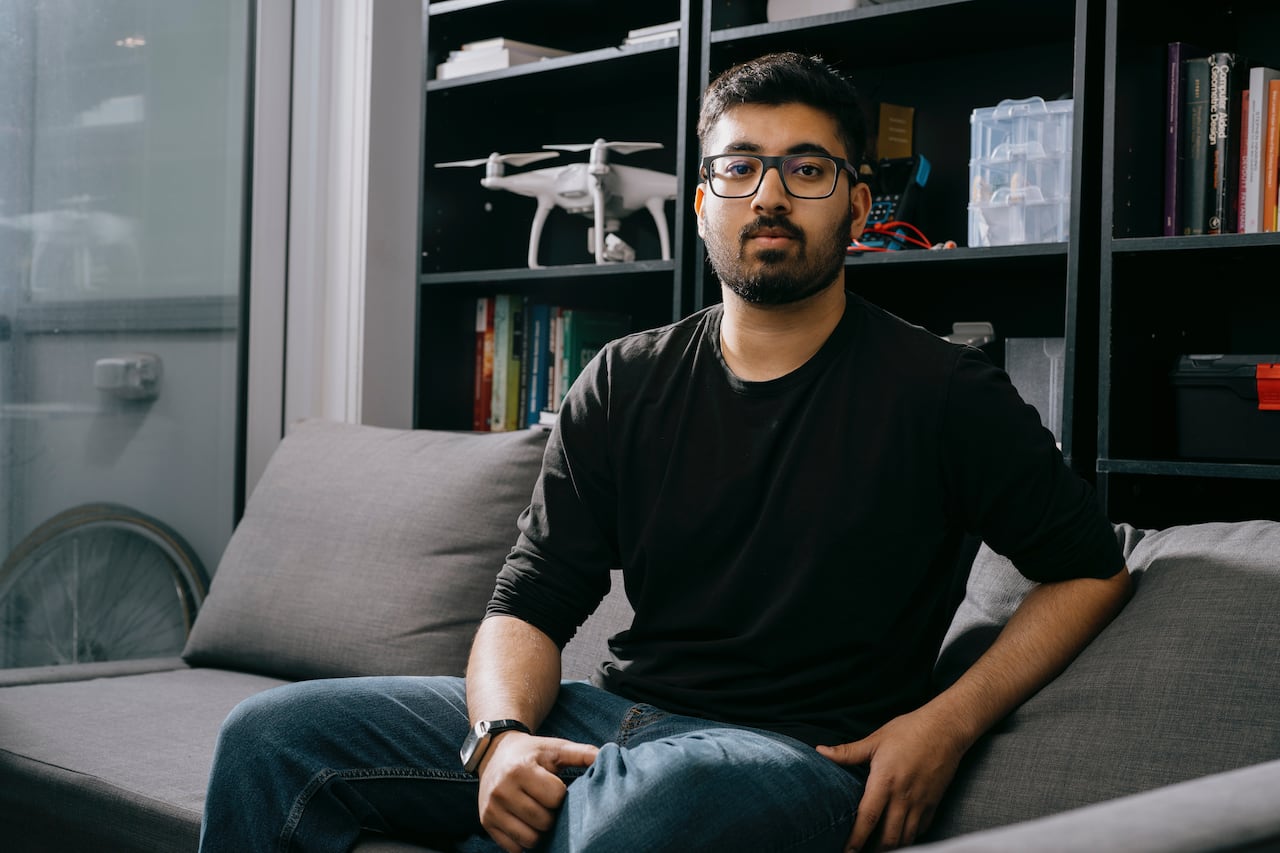 A man sits on a couch and looks at the camera