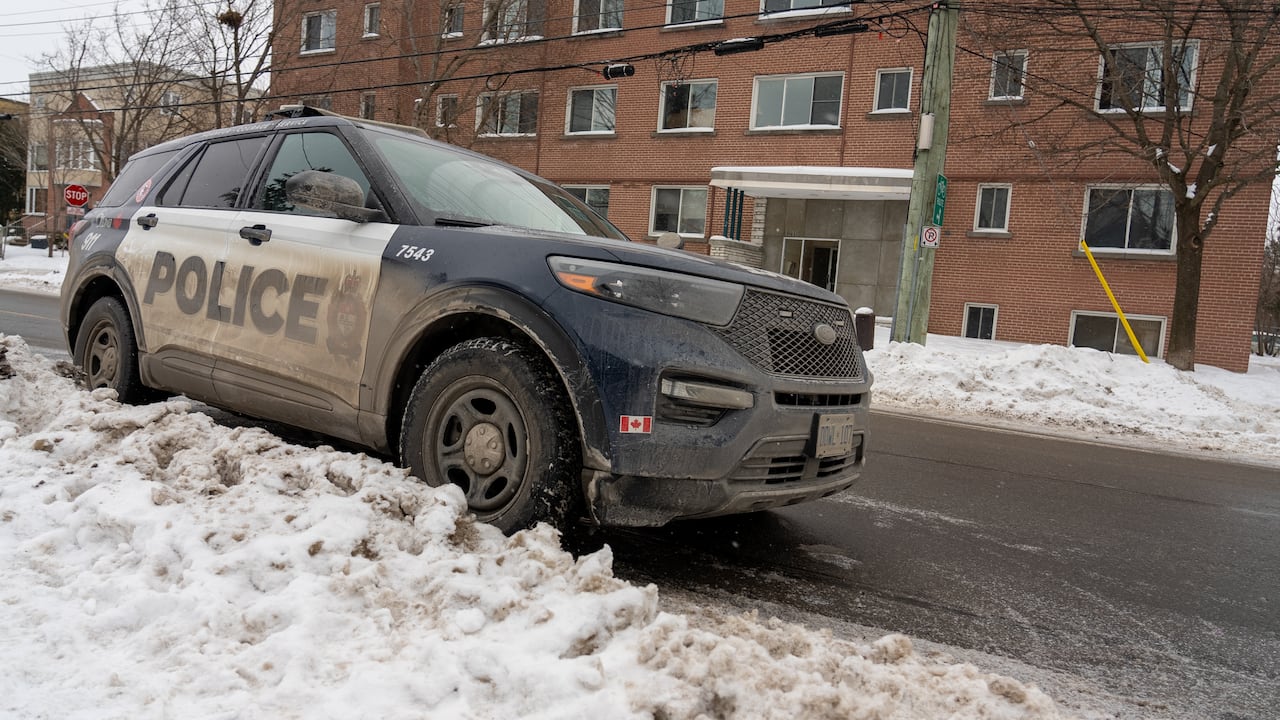 Police vehicles parked on a residential street on a winter morning.