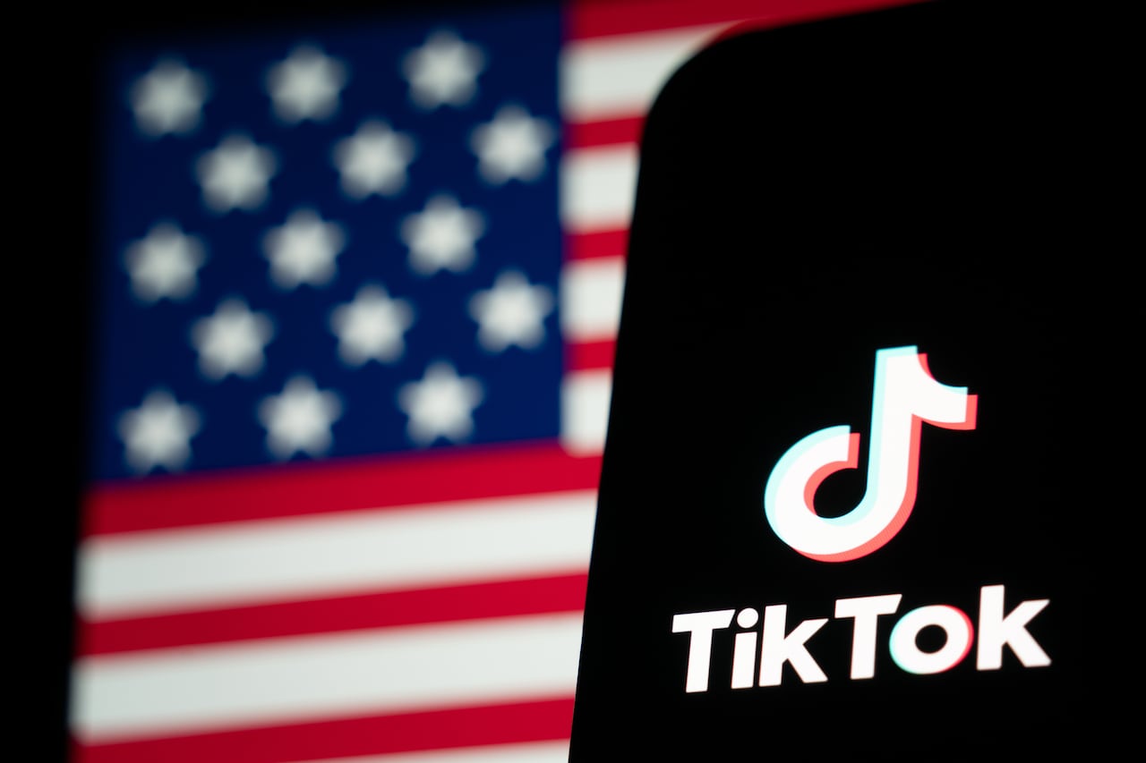 The TikTok logo and flag of the United States are seen on screens.