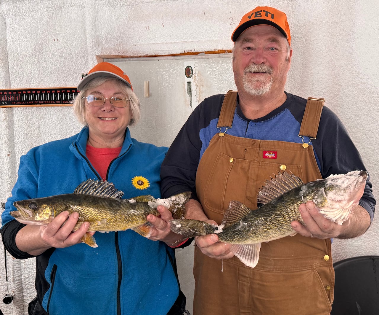 a man and woman holding up fish they caught