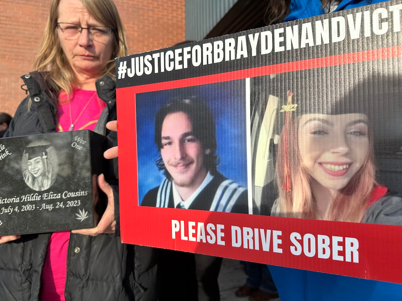 A placard with the photos of a young man and woman are shown.