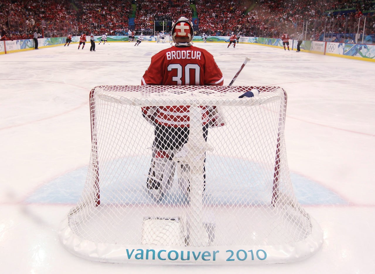 A Canadian ice hockey goaltender looks down the ice during a game.