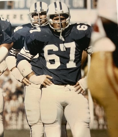 a man in a football outfit stands in a football field