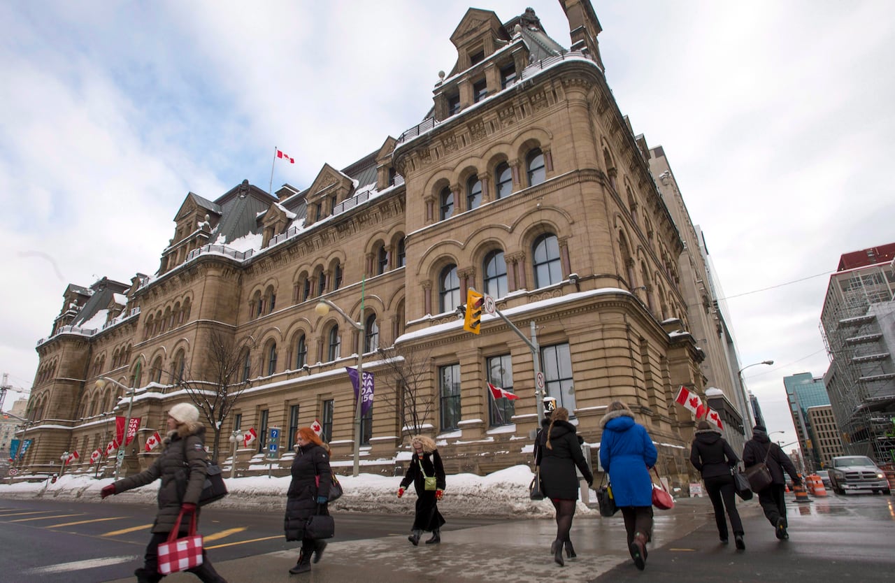 People walk past a downtown Ottawa block across from Parliament Hill.