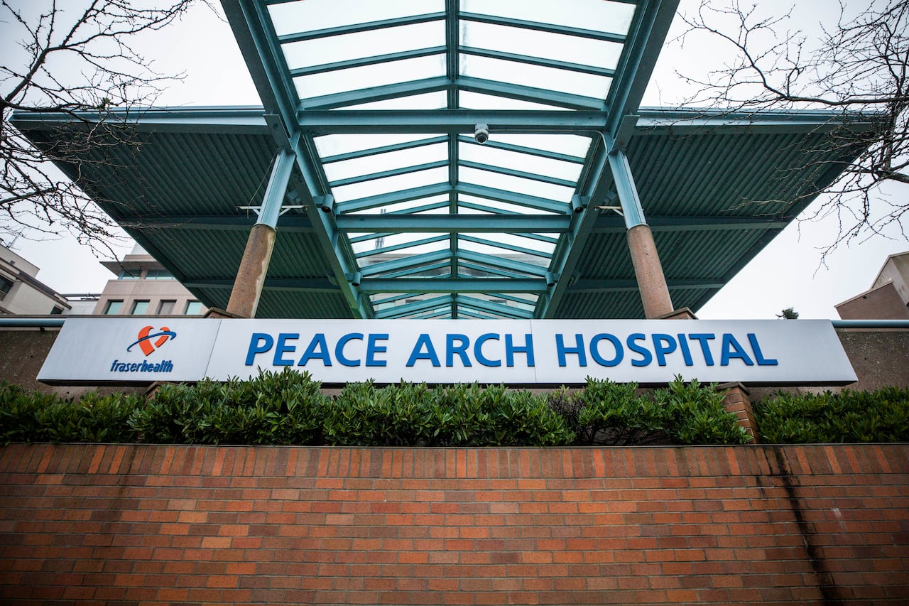A photo of the sign of Peace Arch Hospital over a brick wall, sign also displays Fraser Health logo