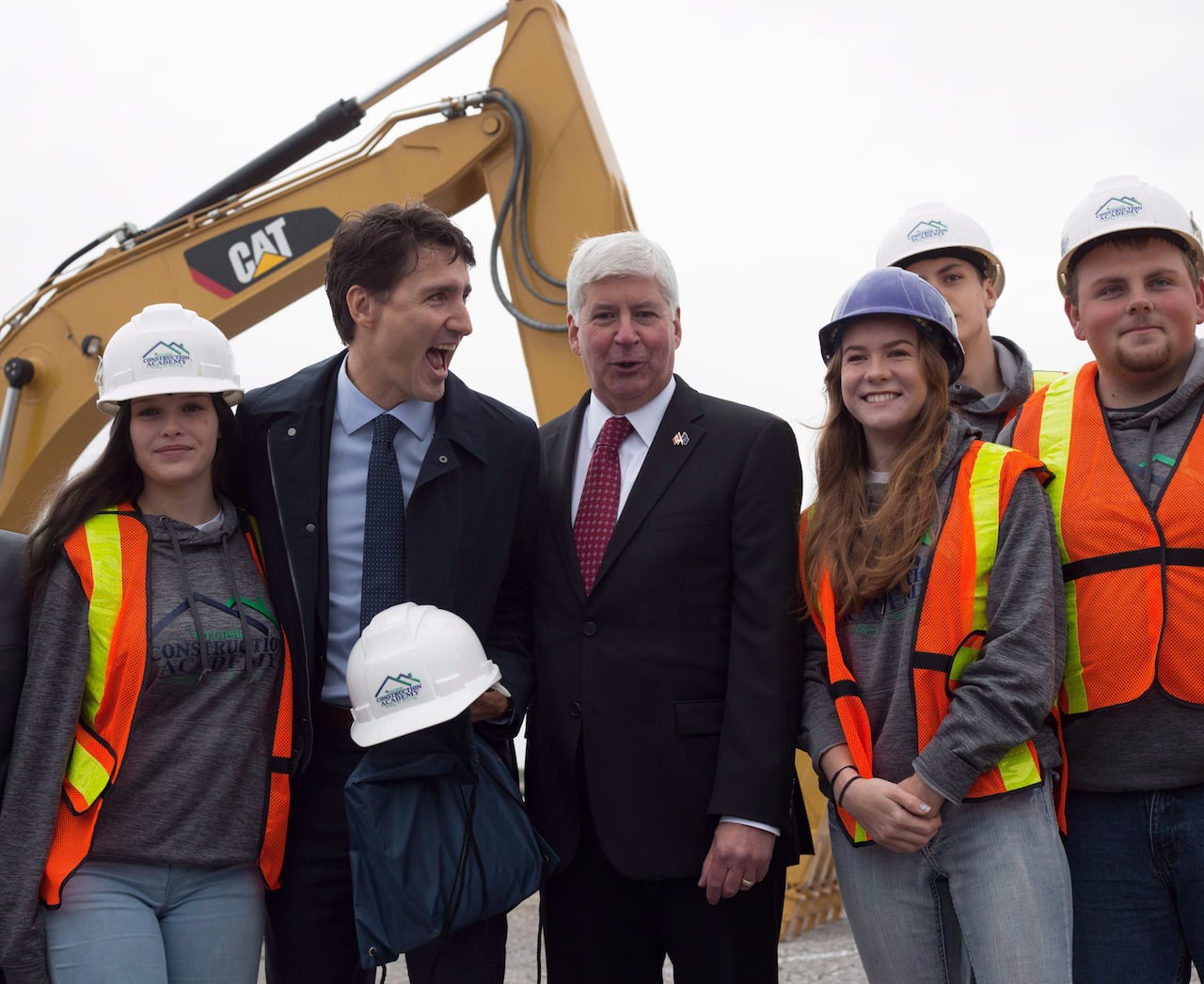 Former prime minister Justin Trudeau and ex-Michigan governor Rick Snyder pose with construction apprenticeship students in Windsor, Ont. Friday, Oct. 5, 2018.