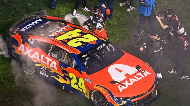 William Byron celebrates next to his car after winning the...