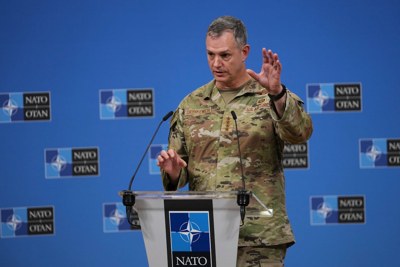 A soldier gestures at a podium.