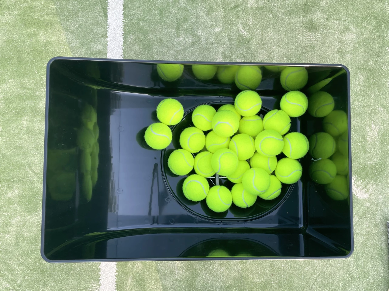 The container can hold 150 balls, which feed into the chute system below