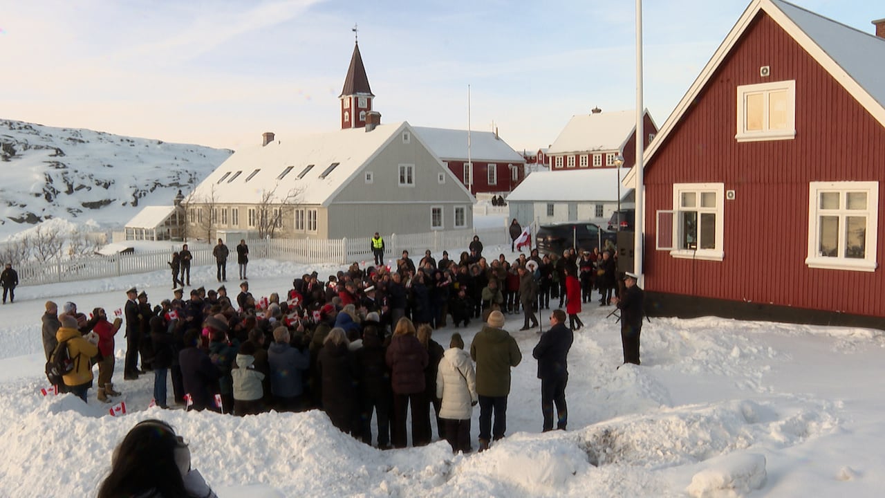 A group of people gather outside a building 