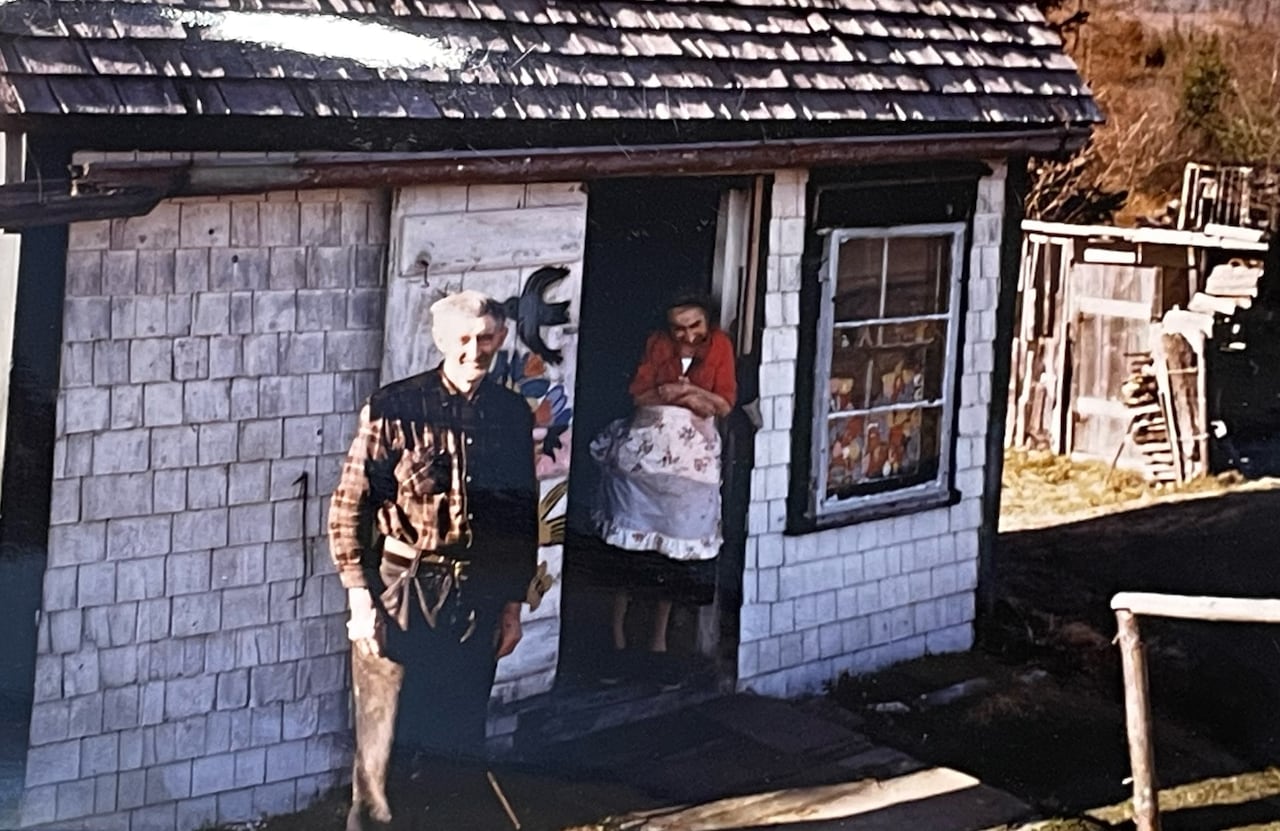 A colour photo shows Everett and Maud Lewis outside of their Digby County, N.S., home.