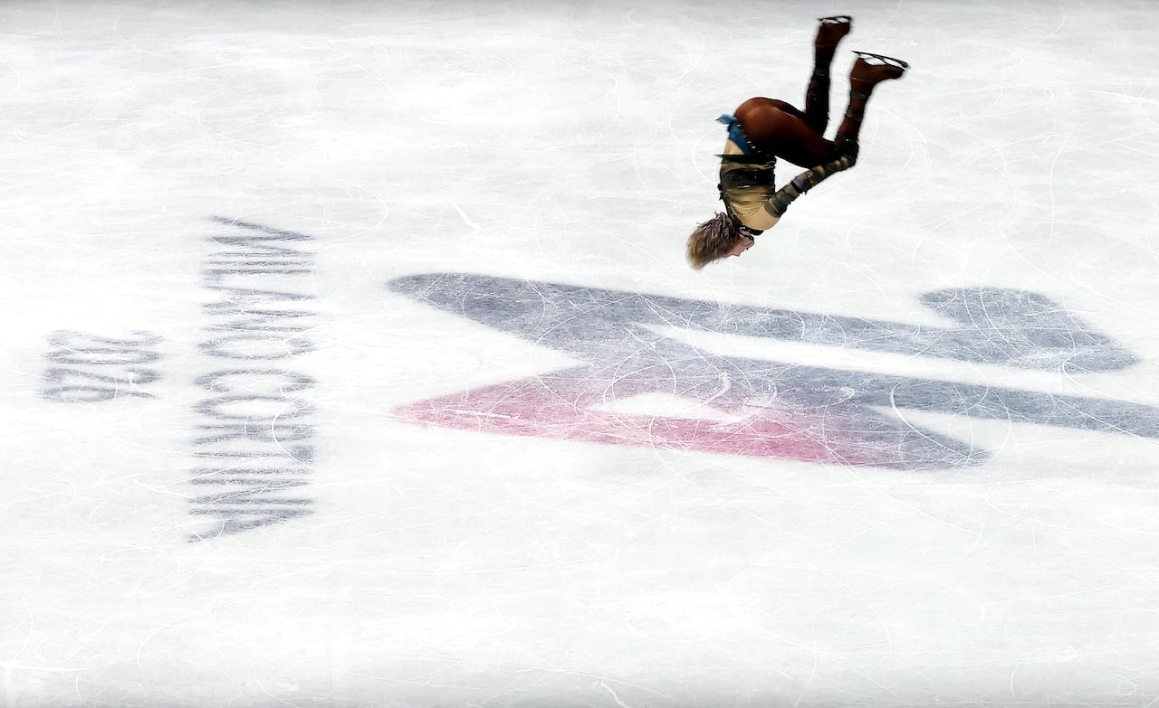 A figure skater jumps.