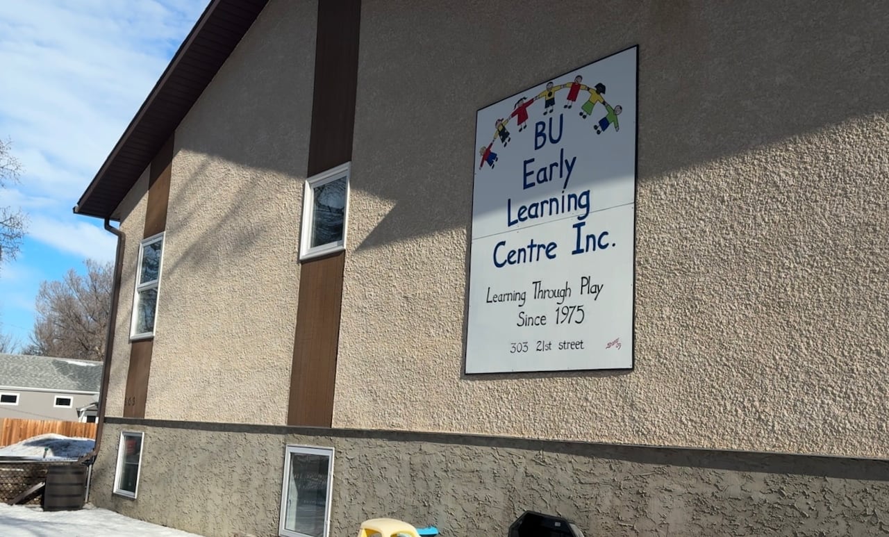 The sun is shining on the west side of a building with a large sign for a children's daycare centre
