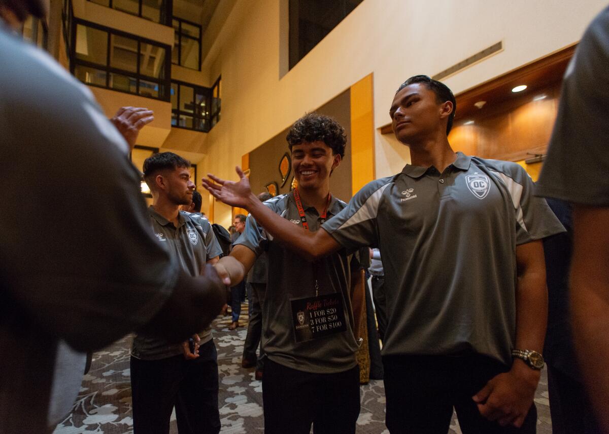 Members of the Orange County Soccer Club shake hands during the team's annual gala in Costa Mesa on Feb. 5.
