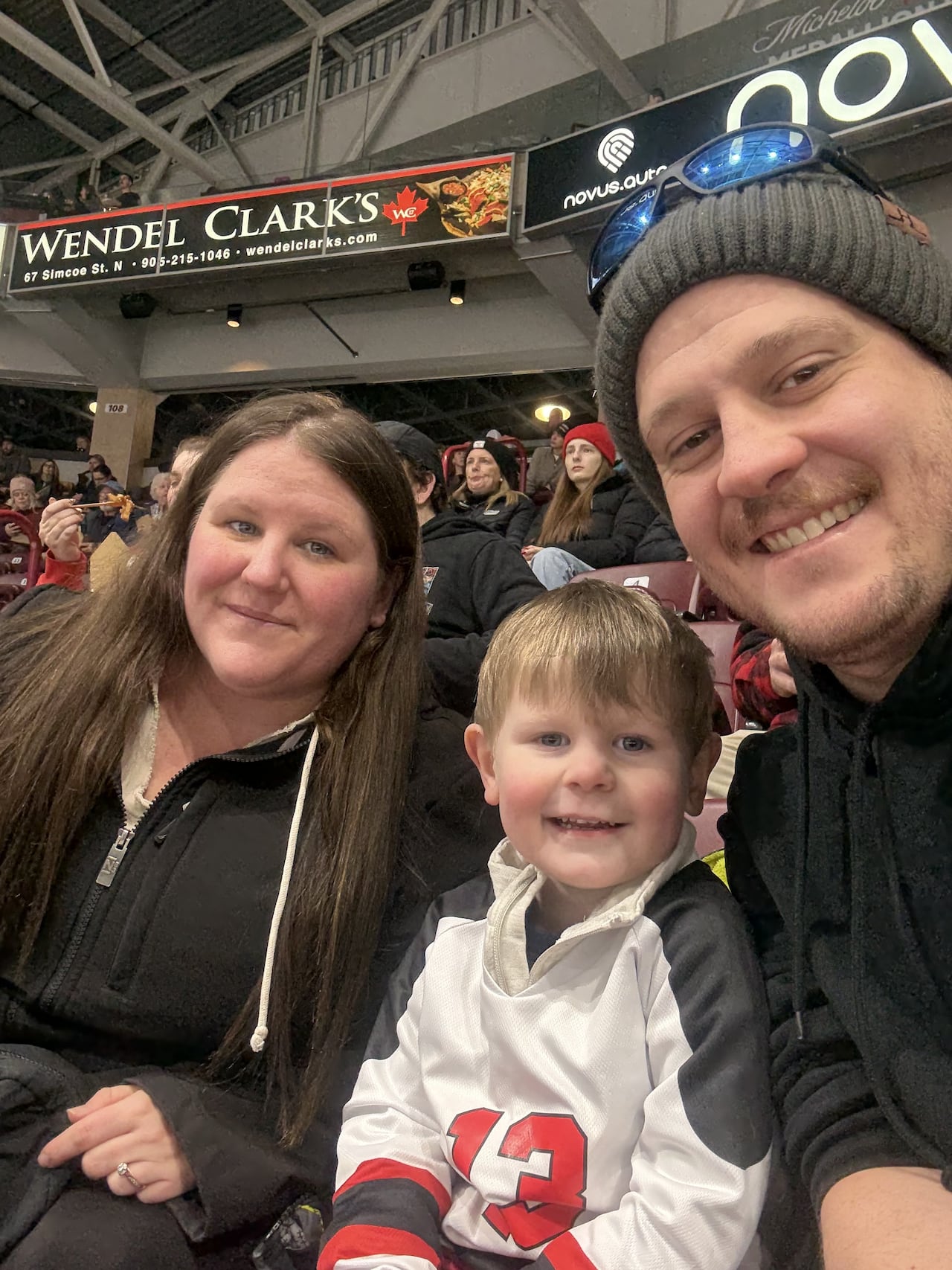 A man, woman and child pictured taking a selfie at a hockey game