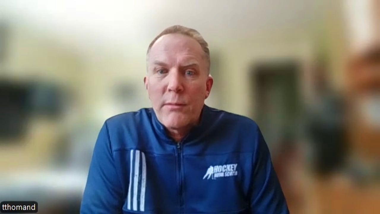 Todd has a Hockey Nova Scotia shirt on while sitting on a Zoom interview with the background blurred. 