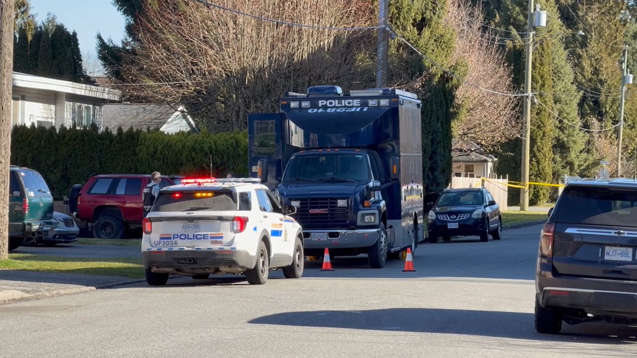 Police cars are parked on a residential street.