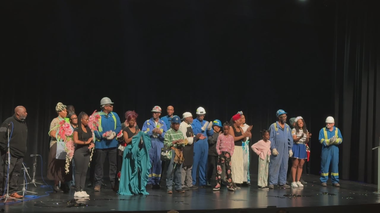 A group of performers standing on stage, accepting the audience's applause and clapping.