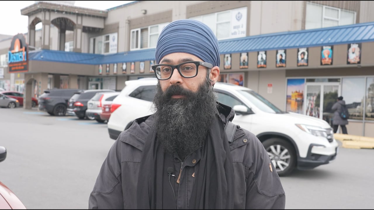A Sikh man speaks outside a gurdwara.