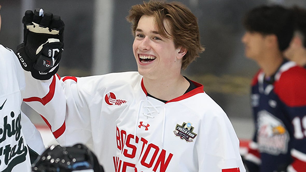 Boston University forward Macklin Celebrini smiles and raises his right arm in celebration after scoring a goal during an NHL draft prospect youth hockey clinic at City National Arena on June 26, 2024 in Las Vegas, Nevada. 