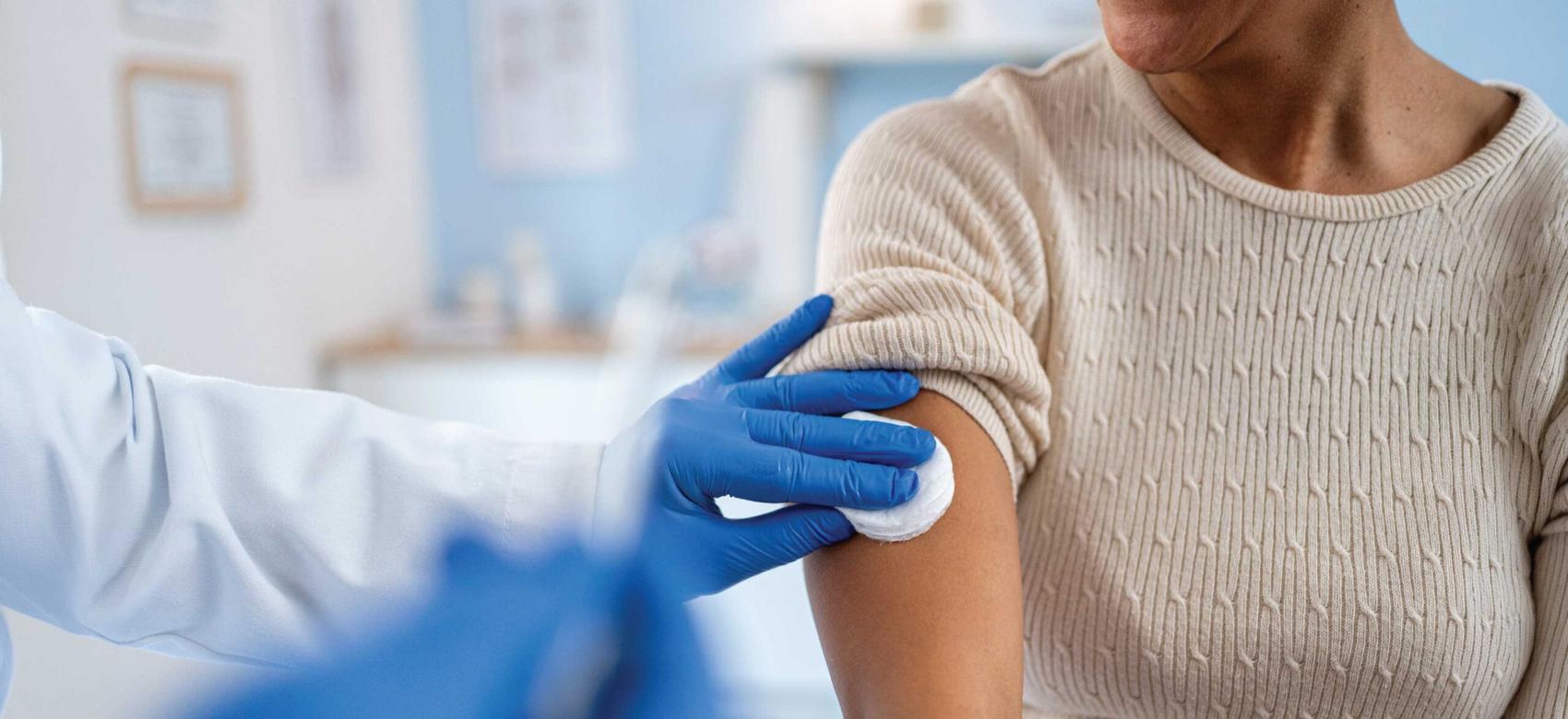 A woman getting a vaccine shot in a clinic