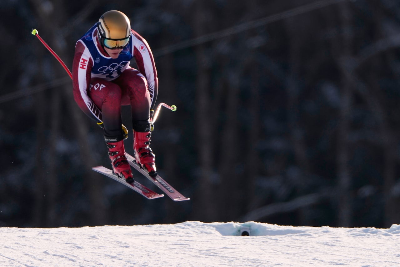 A downhill skier captured mid-flight above the snow.