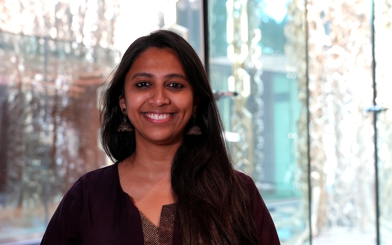 A woman with long black hair smiles.