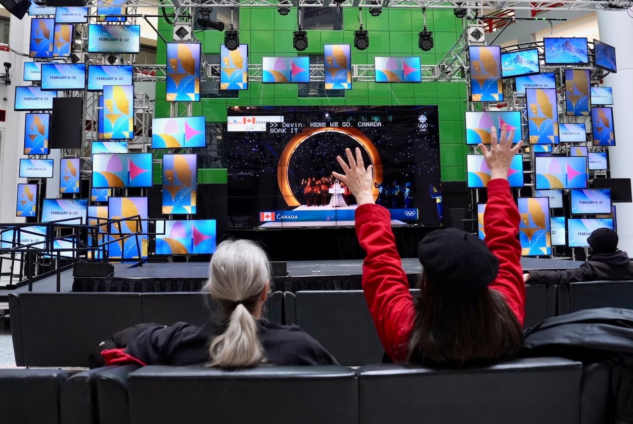 Two people are watching a screen and cheering.