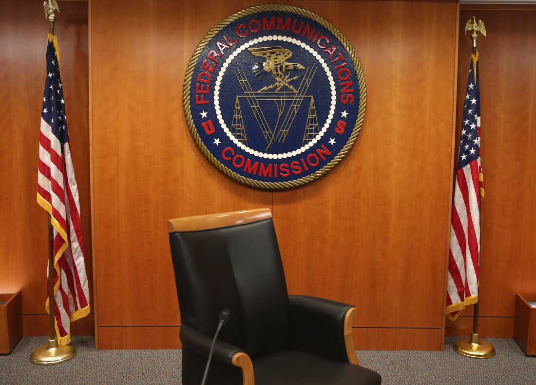 The seal of the Federal Communications Commission hangs between two American flags; the FCC is urging broadcasters to air more "patriotic" content in the run-up to the country's 250th celebrations this summer.